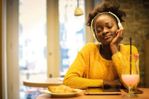 calm woman in yellow with headphones on 