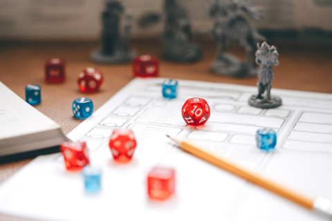 Colorful dice and game figures on a piece of paper.