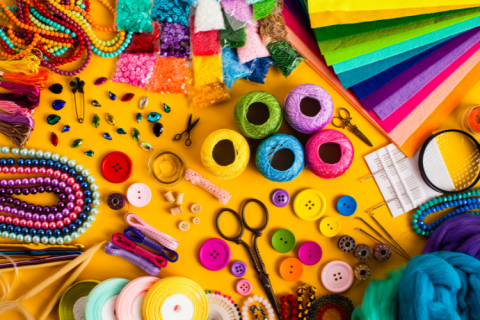 Colorful paper, string, scissors and other craft supplies laid out on a table.