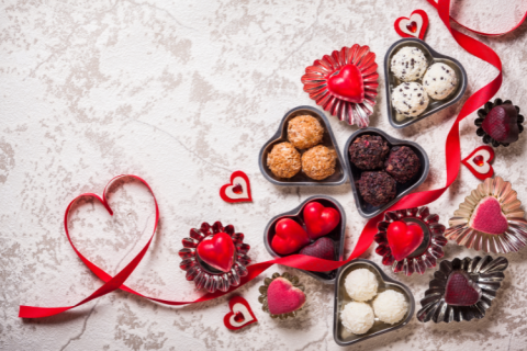 Chocolate hearts with red wrappers and ribbons