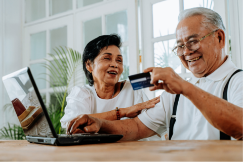 Adult man and woman with credit card and laptop computer