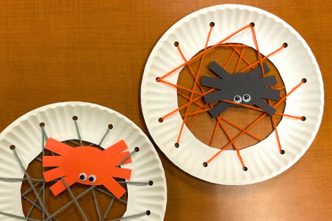 Construction paper spiders in a yarn web 