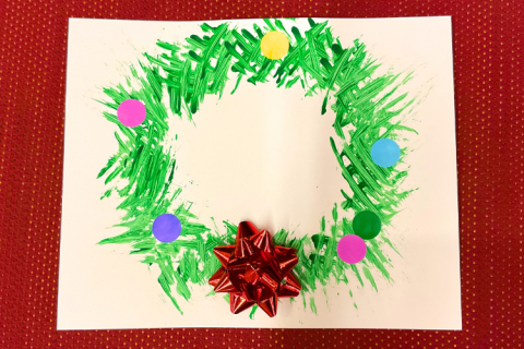 Painting of a green wreath with a red bow at the bottom