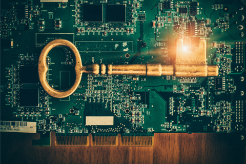 An old-fashioned brass key on a green computer motherboard.