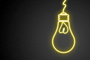 Neon outline of lightbulb on black background