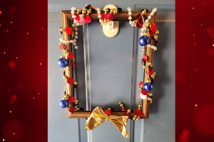 Holiday wreath made from an empty picture frame wrapped in decor