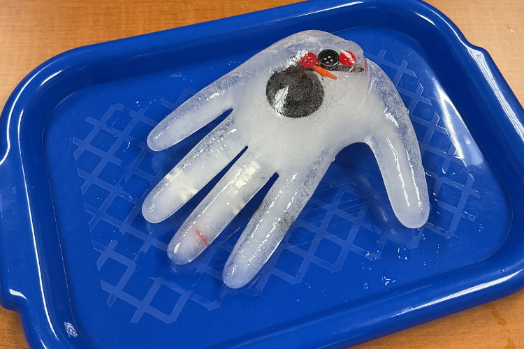 Ice shaped like a hand on a blue tray