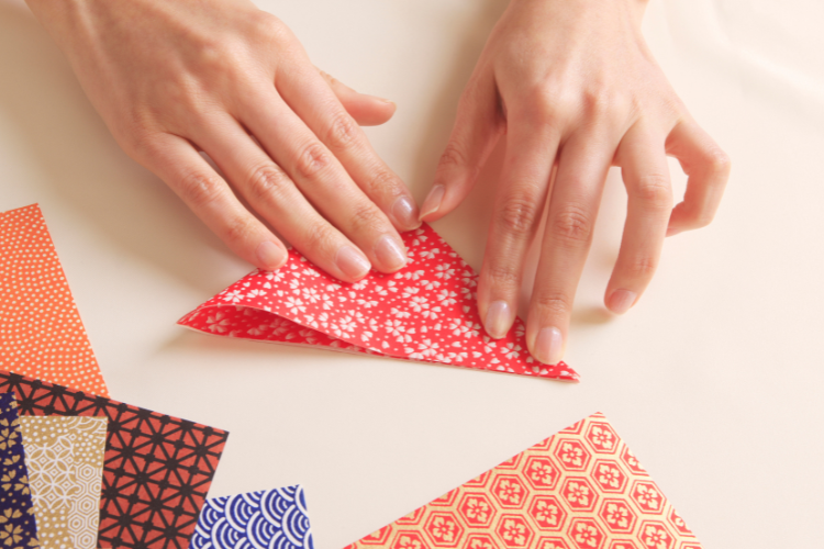 Hands folding decorative paper