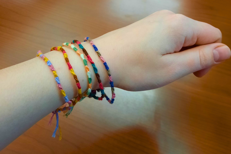 A hand and wrist modeling 5 colorful string bracelets 