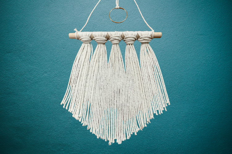 White string craft hanging on blue wall