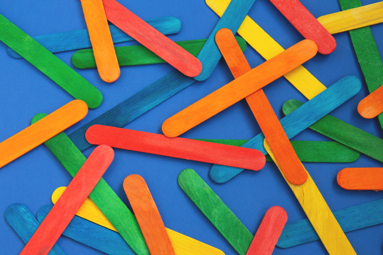 A pile of colorful popsicle sticks on a blue background