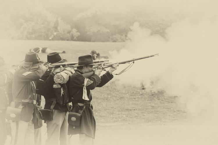 Sepia photo of three men firing guns in Union soldier uniforms
