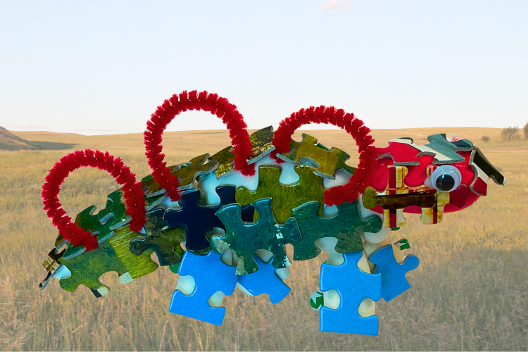 A 3-dimensional dinosaur made of puzzle pieces and pipe cleaners