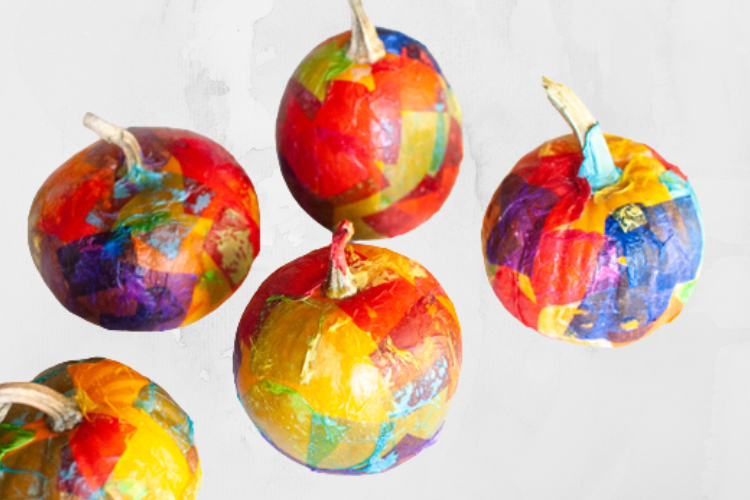 5 small pumpkins covered in scraps of colorful tissue paper